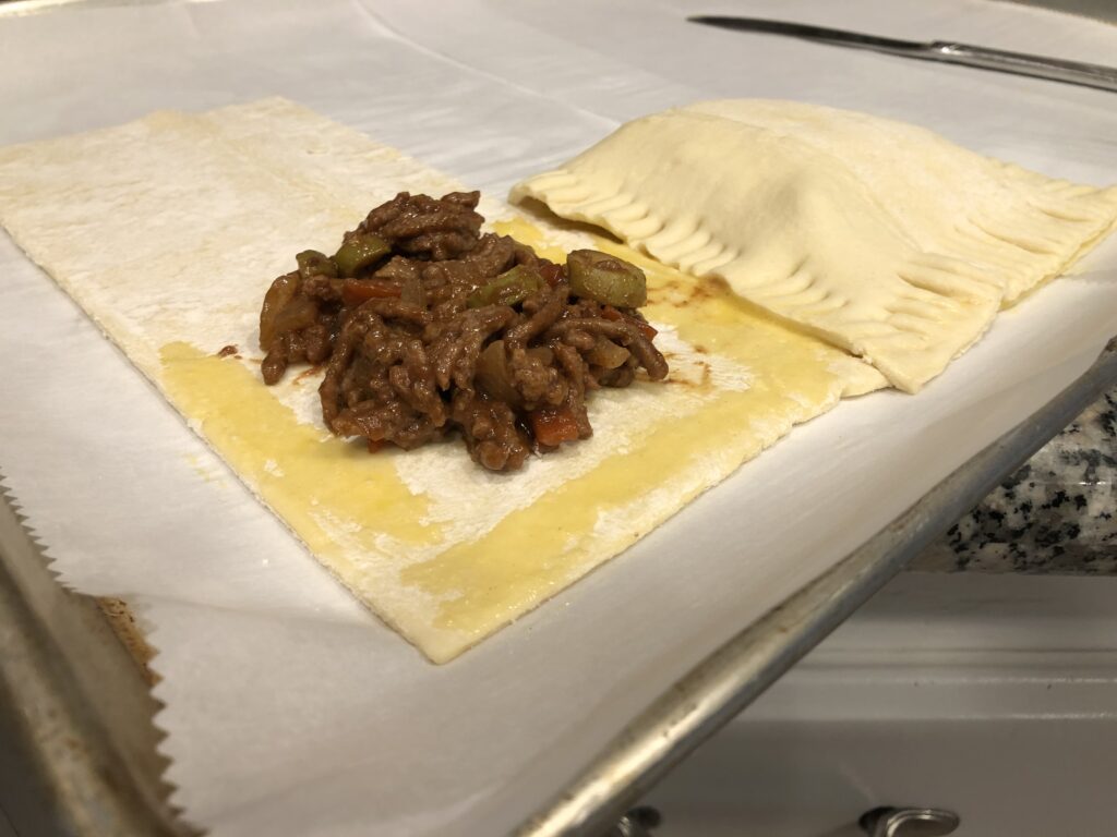 filling empanada with egg wash